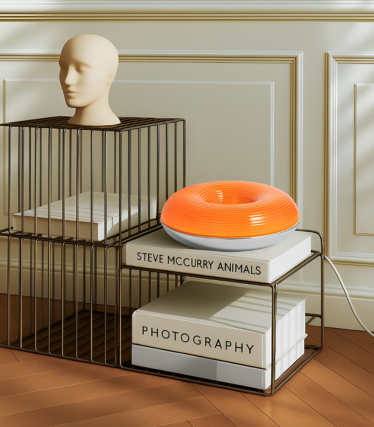 Modern Lindby bordslampa i levande orange på ett dekorativt hyllsystem.
